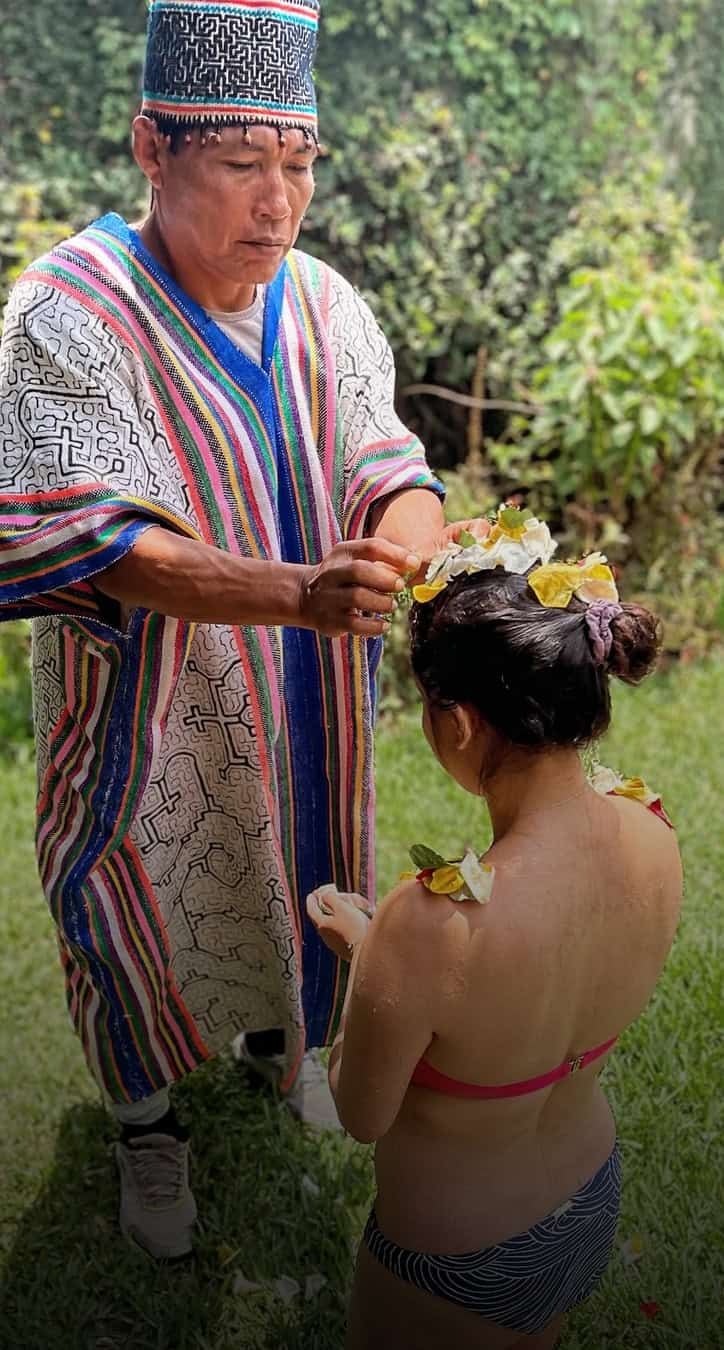 Shaman putting flowers on passenger's head during flower ceremony